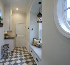 Oval window on right looks out to garden as one descends the two stairs into the mud room.