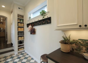 Phone charging station and hooks for coats and bags, cubbies with antique locker baskets hold hats and mittens.